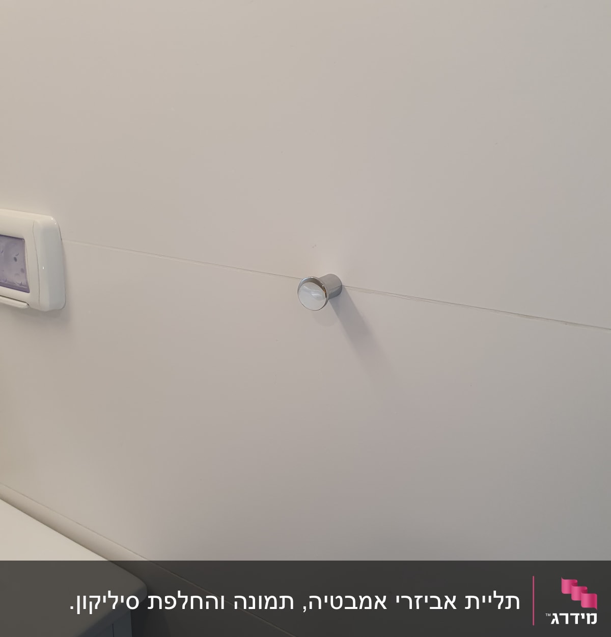 ידית מתכת עגולה מותקנת על קיר לבן